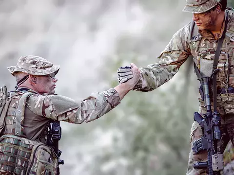 one soldier lends a hand to another