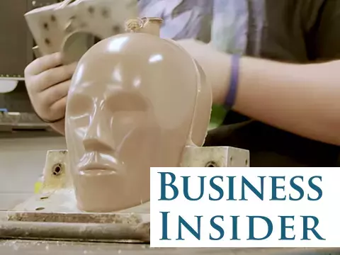 Close up of crash test dummy head mold with employee working in background