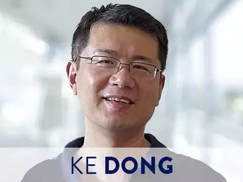 Headshot of Ke Dong with blurred office setting in background