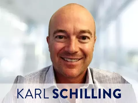 Headshot of Karl Schilling with blurred office background
