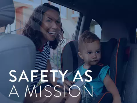 Mom buckling a child in to a car seat.
