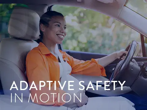 A young, pregnant female driving with a seatbelt on.