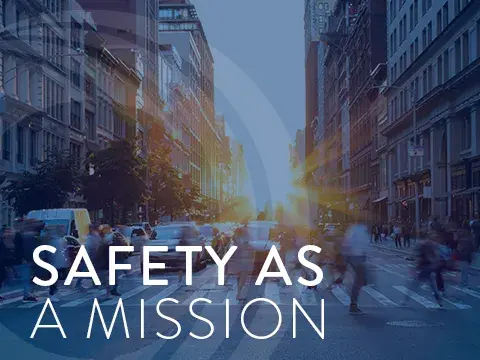 People walking across a busy street on crosswalk.