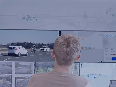 Person in front of bank of computers with TrackBase Connect software running